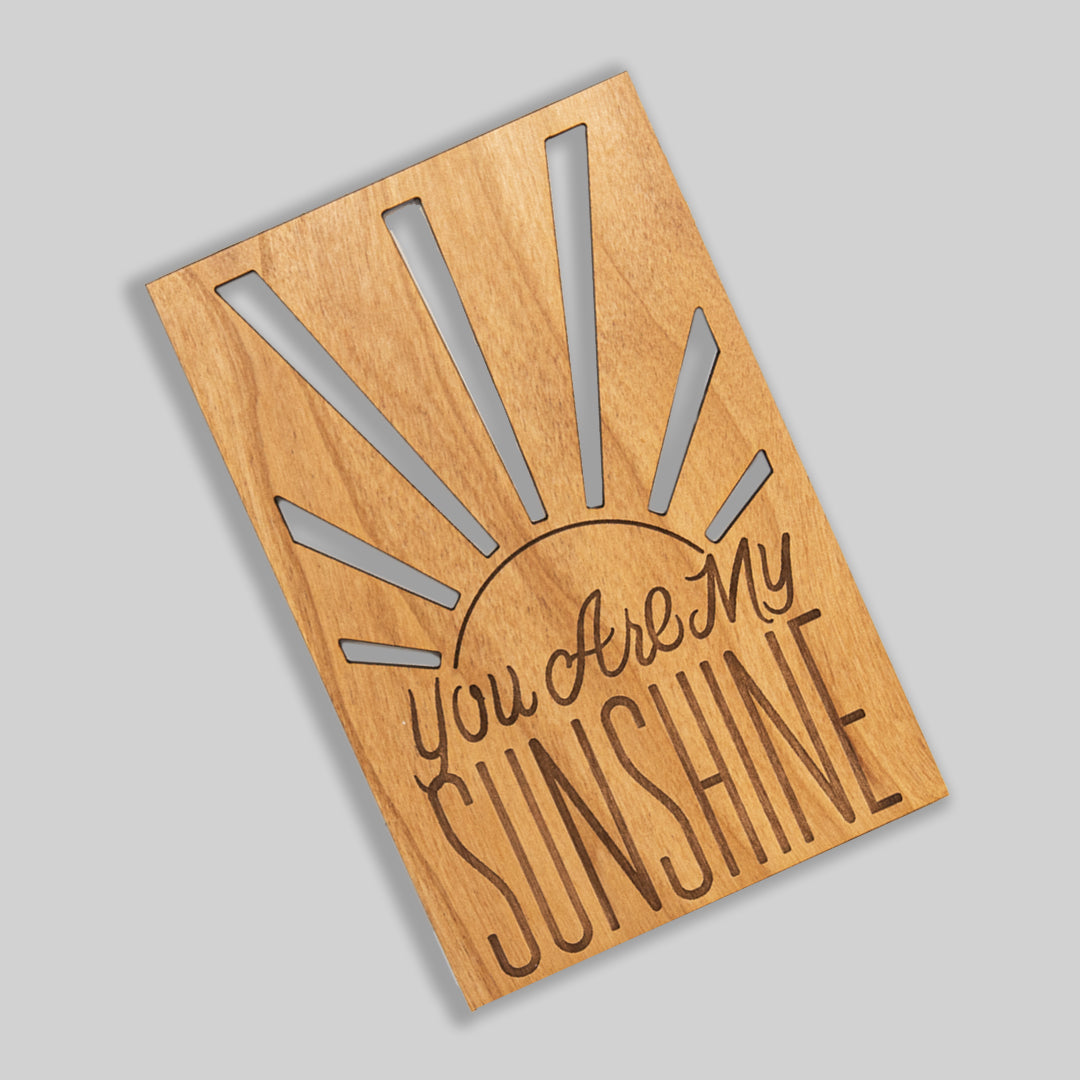 Wood Card that says "You are my sunshine" Rays of the sun are cut out radiating from side to side 